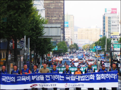 기수단 뒤쪽으로는 '국립대법인화 철회'요구를 담은 현수막을 들고, 노동자들이 거리행진을 하고 있다. 